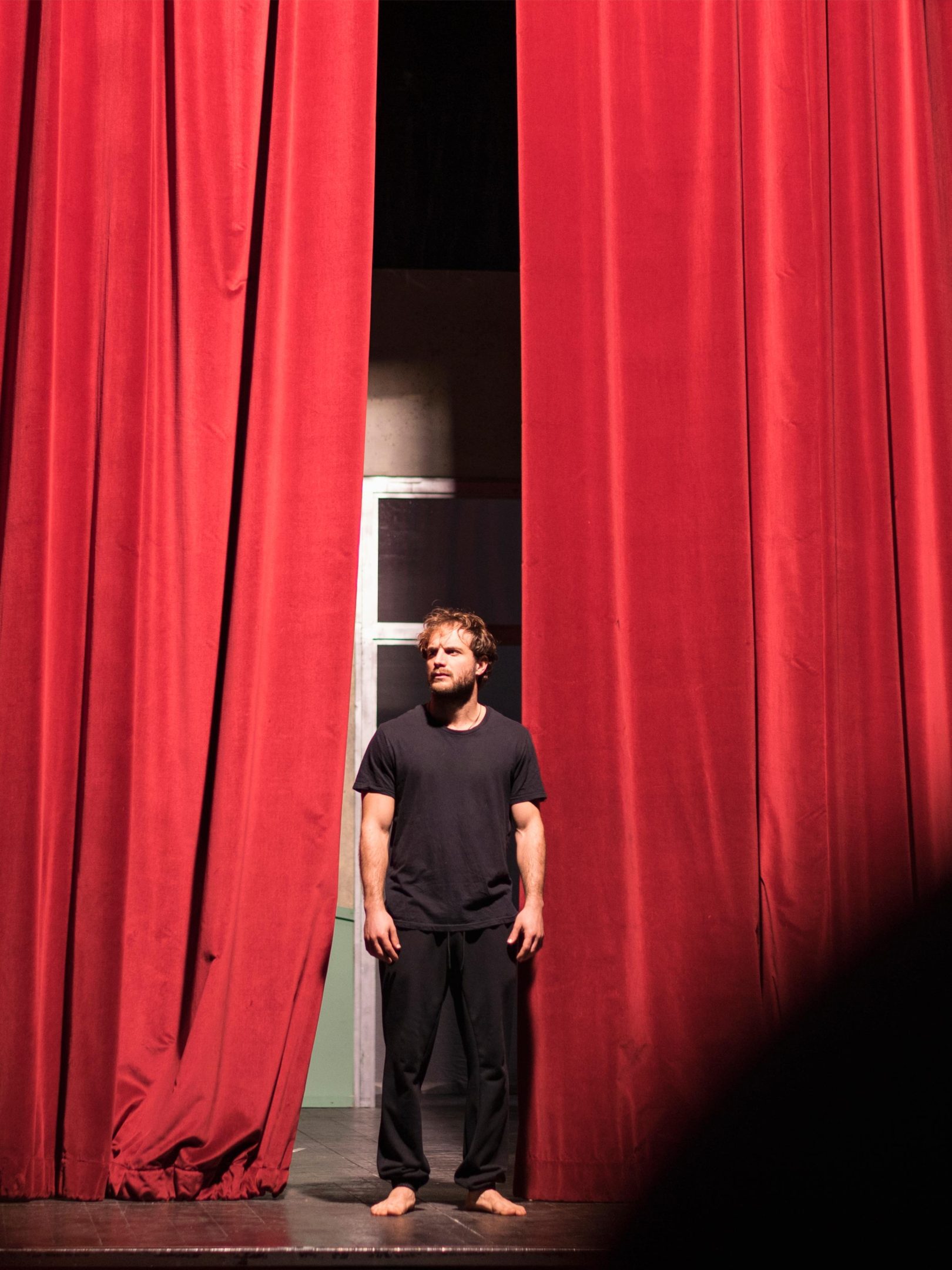 Actor saliendo de los telones rojos