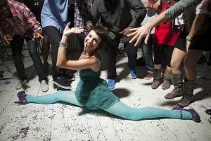Bailarina haciendo un split con ungrupo de amigos
