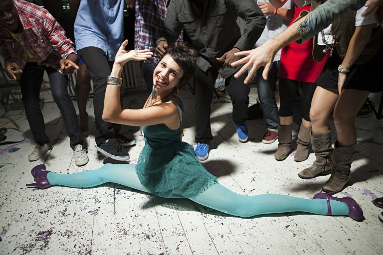 Bailarina haciendo un split con ungrupo de amigos