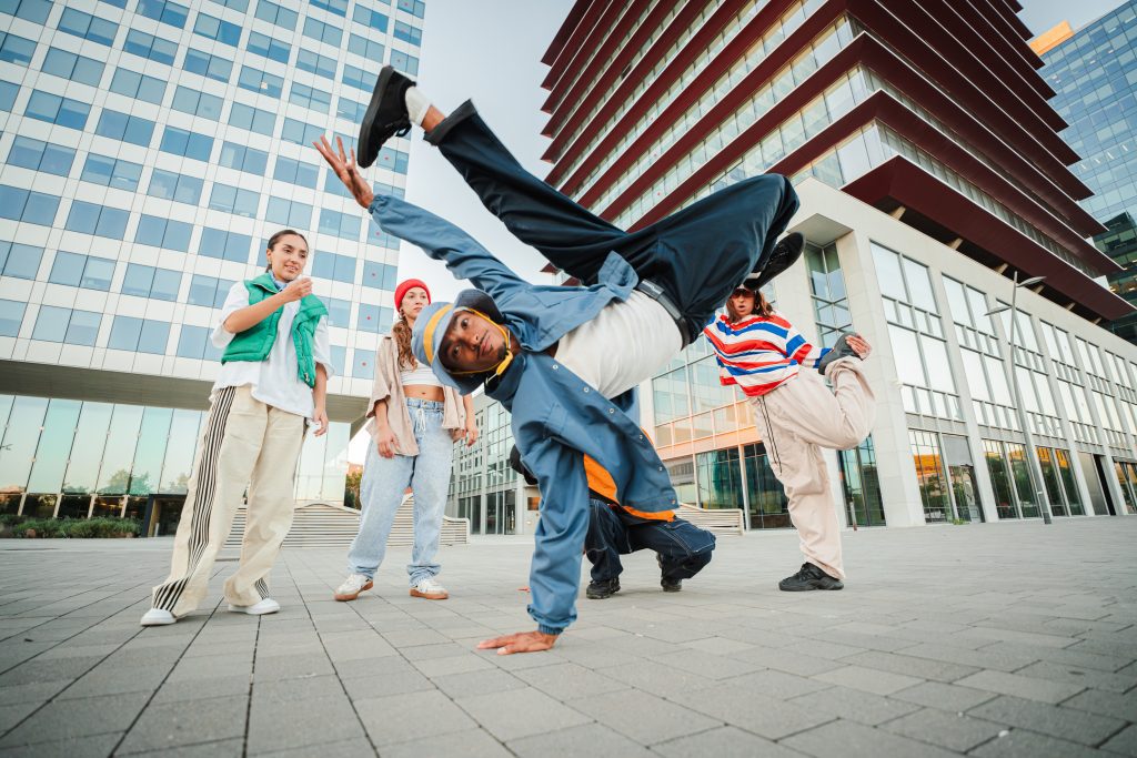Grupo de bailarines de danzas urbanas en la calle bailando y haciendo figuras de Break dance